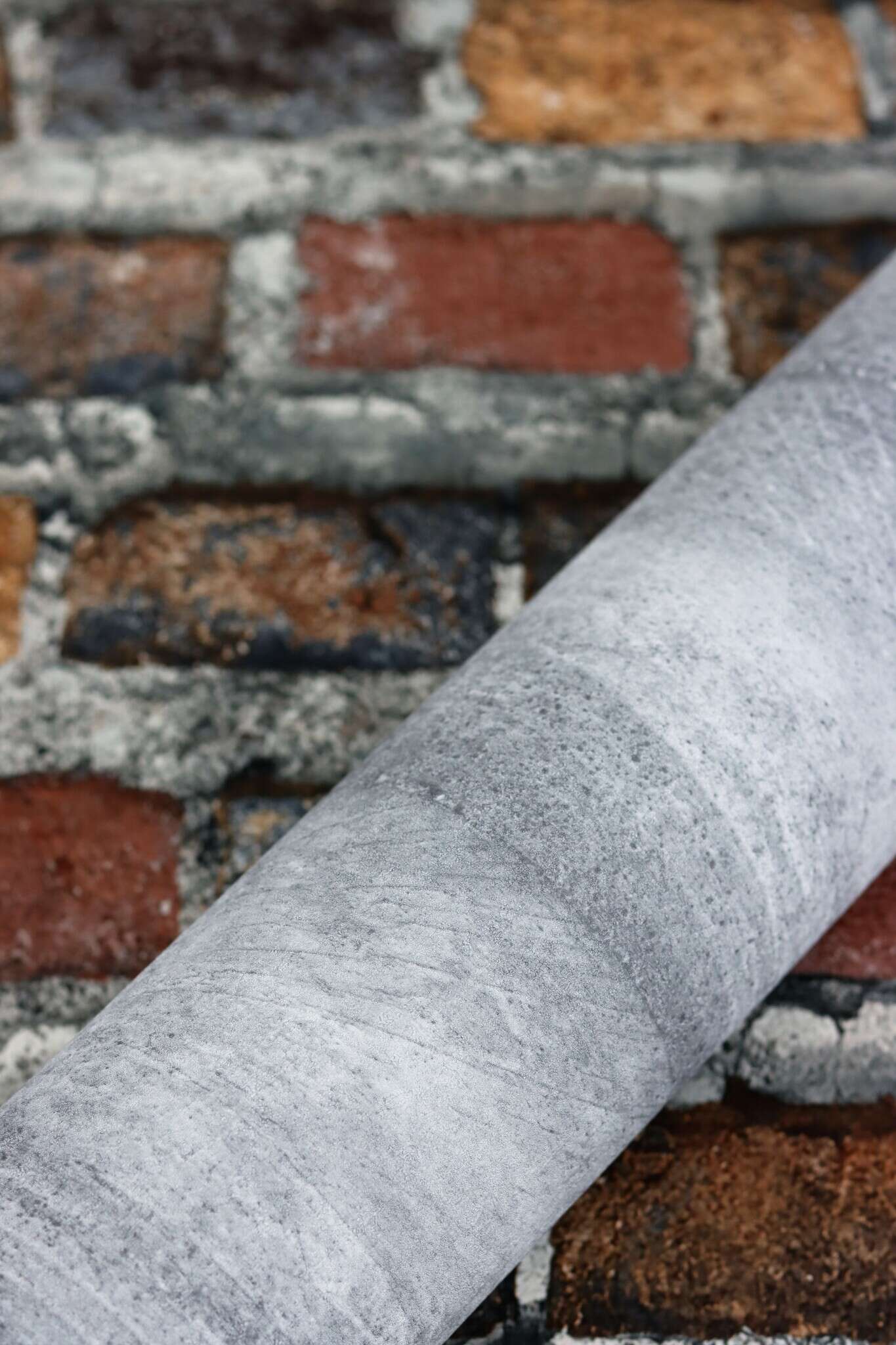 10-428063 Detailaufnahmen 7 Detailed image of Non-woven wallpaper with classic brick pattern in reddish-brown shades.
