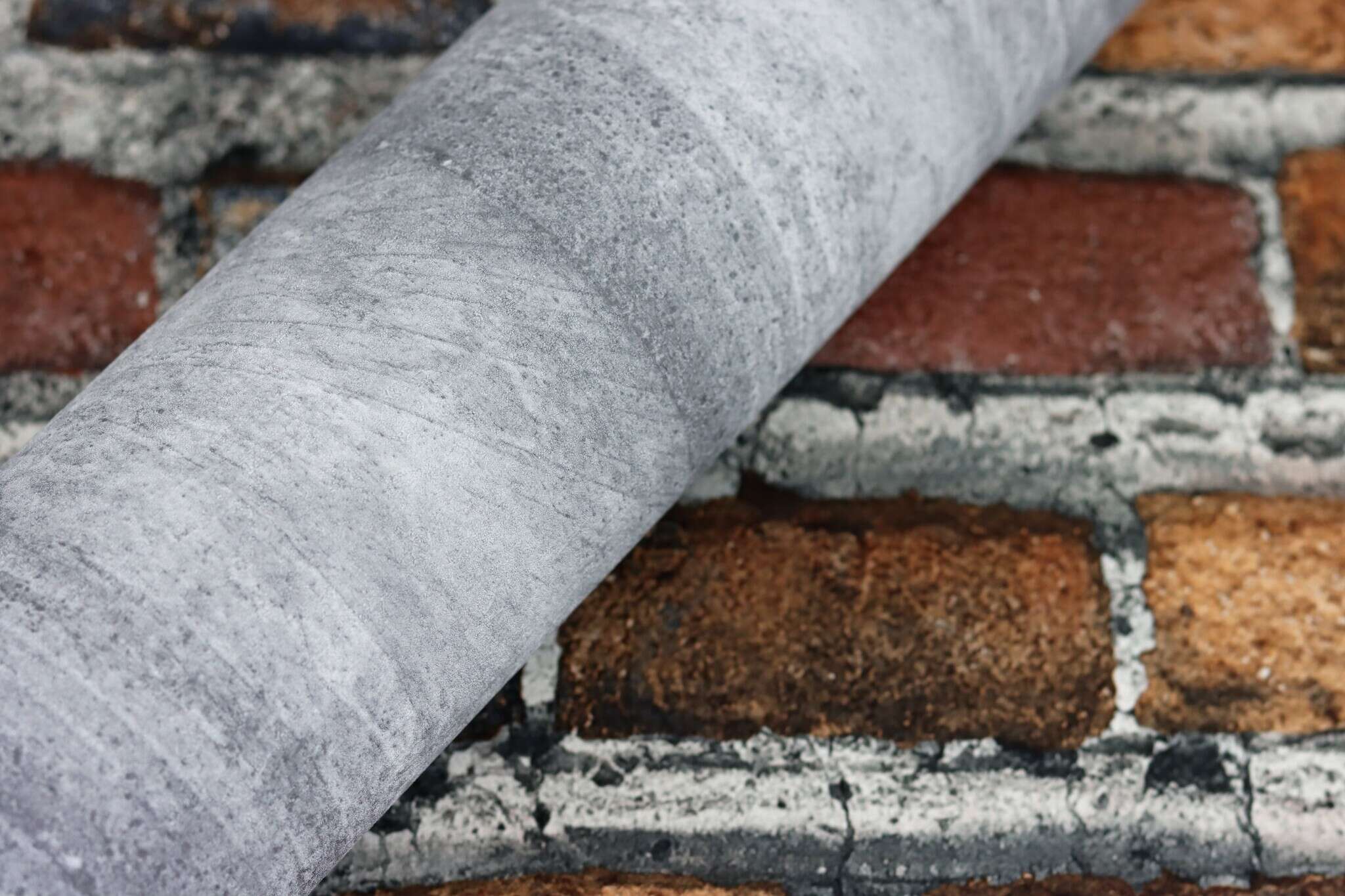 10-428063 Detailaufnahmen 10 Detailed image of Non-woven wallpaper with classic brick pattern in reddish-brown shades.