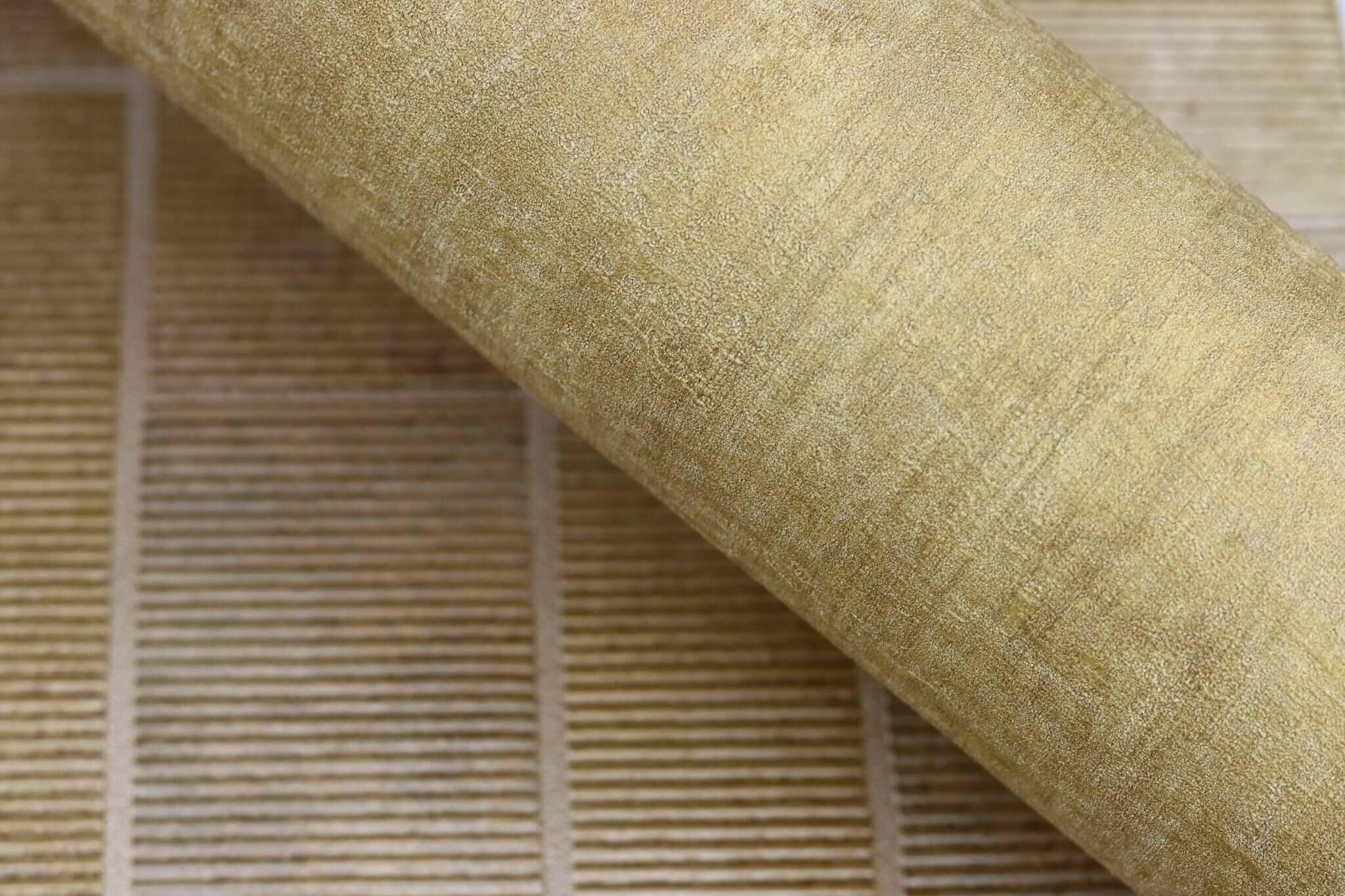 10-429312 Detailaufnahmen 23 Detailed image of Non-woven wallpaper with a textured surface in a mustard yellow colour.