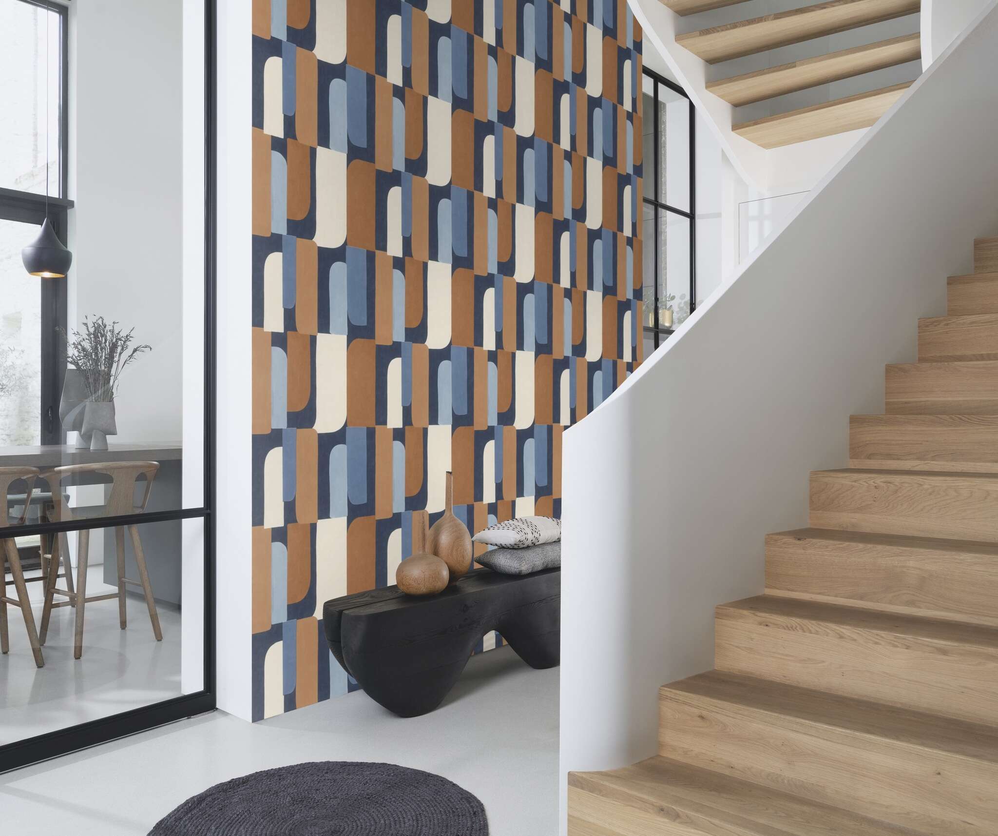 10-330519 Raumsituationen 3 Une chambre avec Papier peint à grands motifs dans les tons bleu, beige et cognac – vibrant et graphique.
