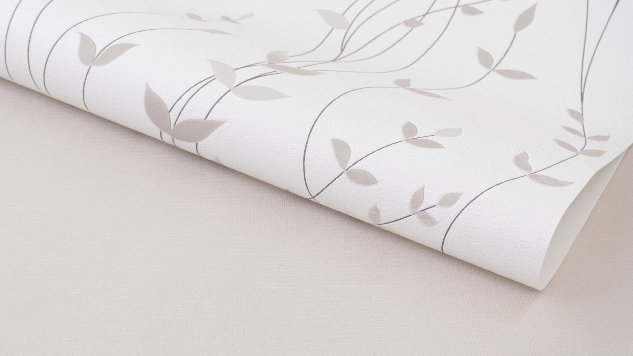 10-416022 Detailaufnahmen 1 Detailed image of Non-woven wallpaper with a fine, curved tendril pattern in beige on a light background.