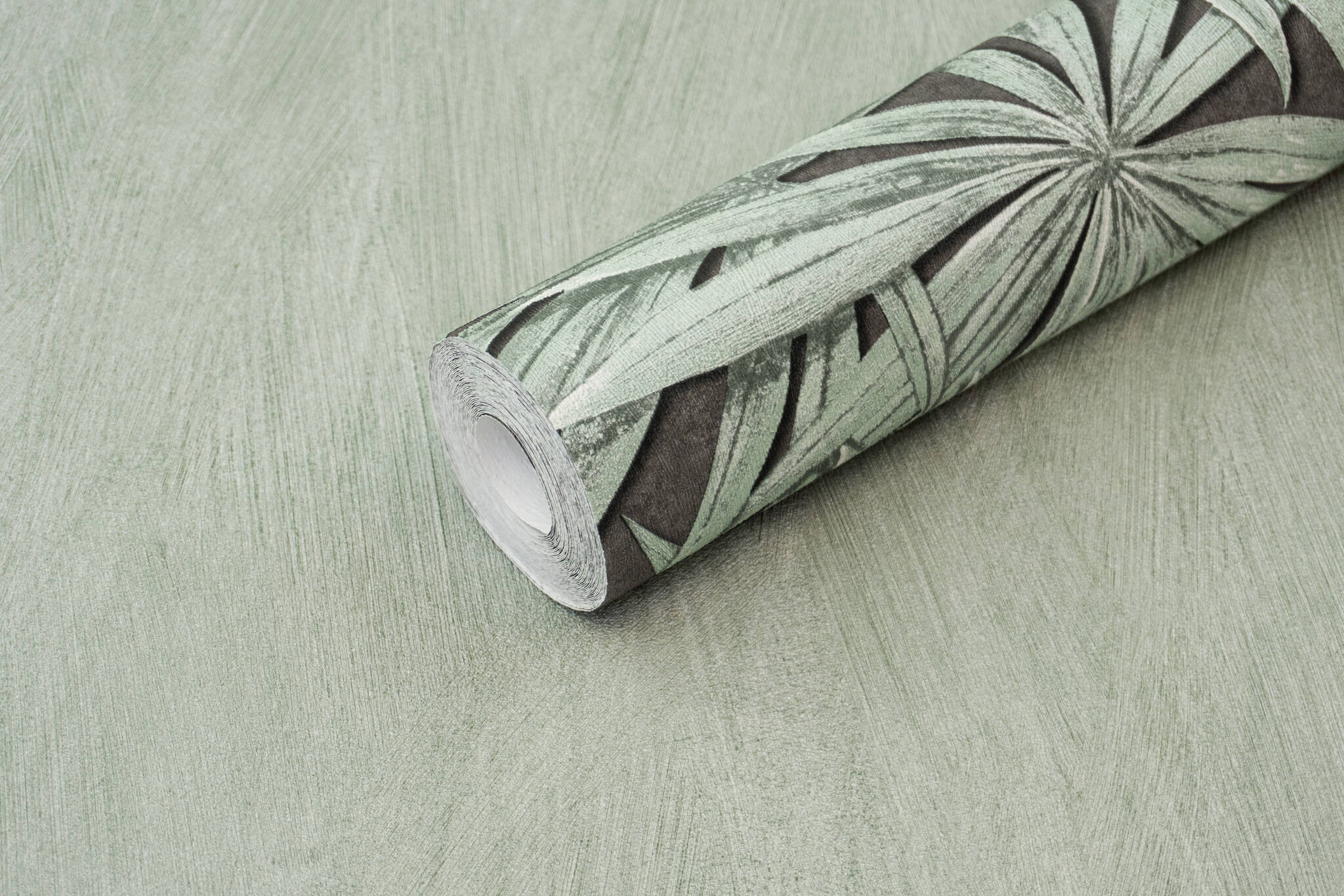 10-542561 Detailaufnahmen 1 Detailed image of Palm fronds in mint green on a shimmering, dark grey background with a plaster look