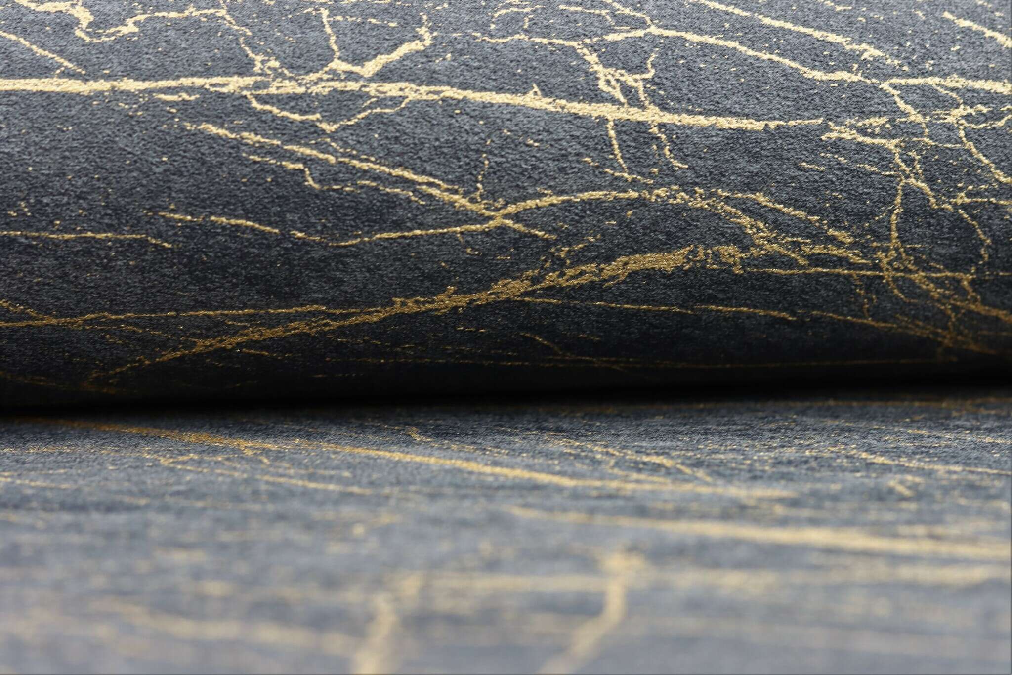 10-428964 Detailaufnahmen 12 Detailed image of Non-woven wallpaper in black marble look with irregular gold-coloured veining.