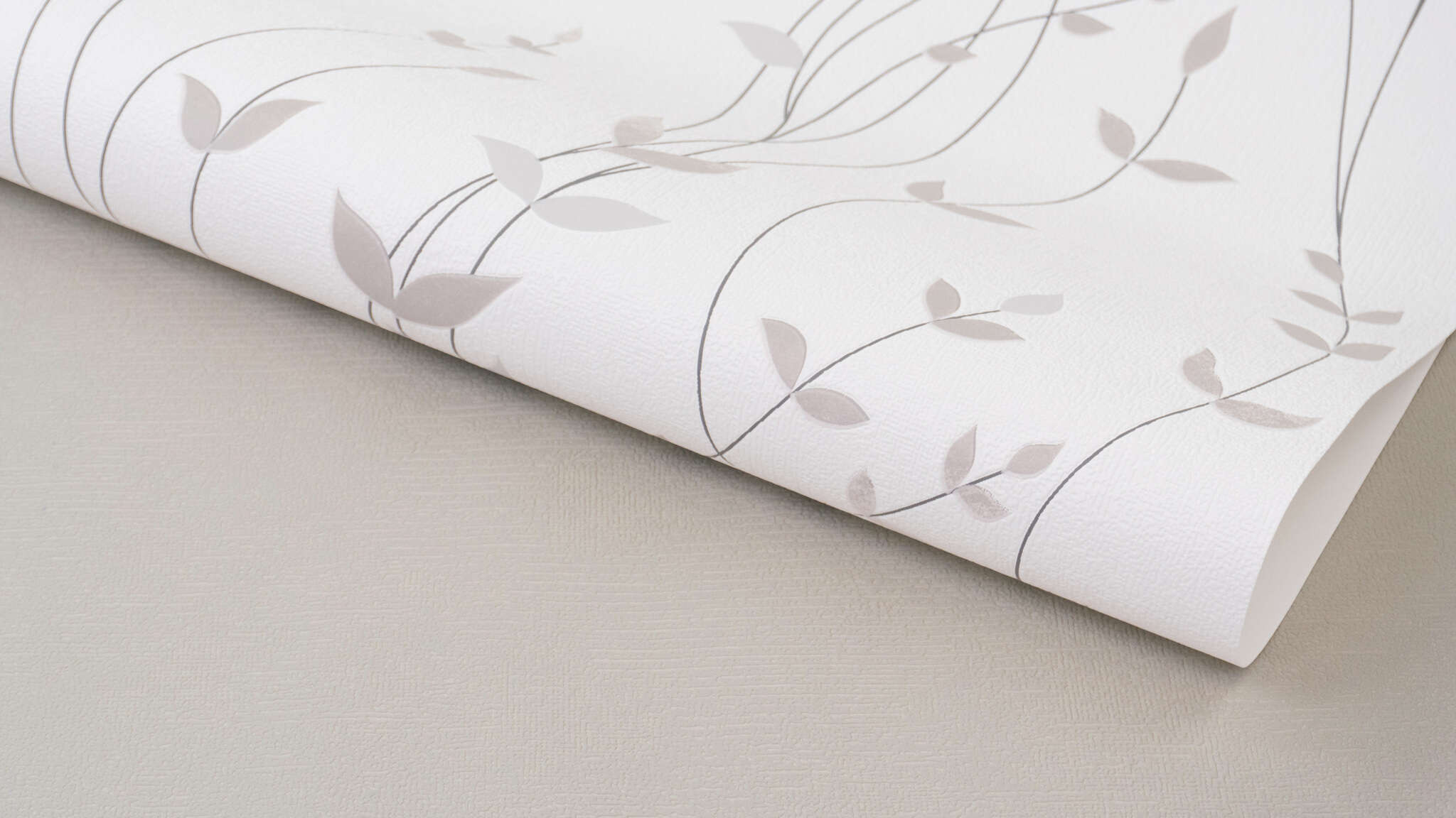 Detailed image of Non-woven wallpaper with a fine, curved tendril pattern in beige on a light background.