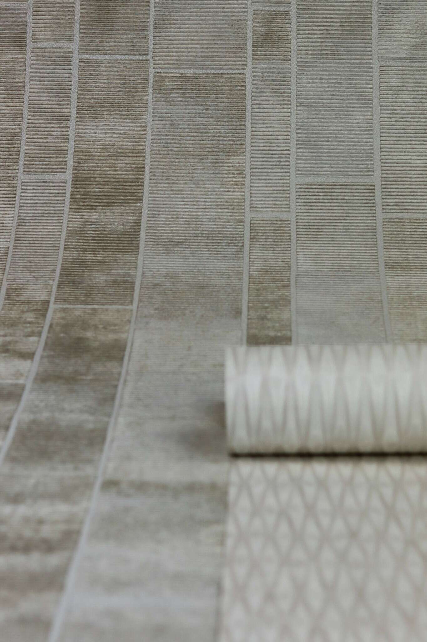 10-428209 Detailaufnahmen 5 Detailed image of Non-woven wallpaper with rectangular tile pattern in various beige tones with concrete texture.