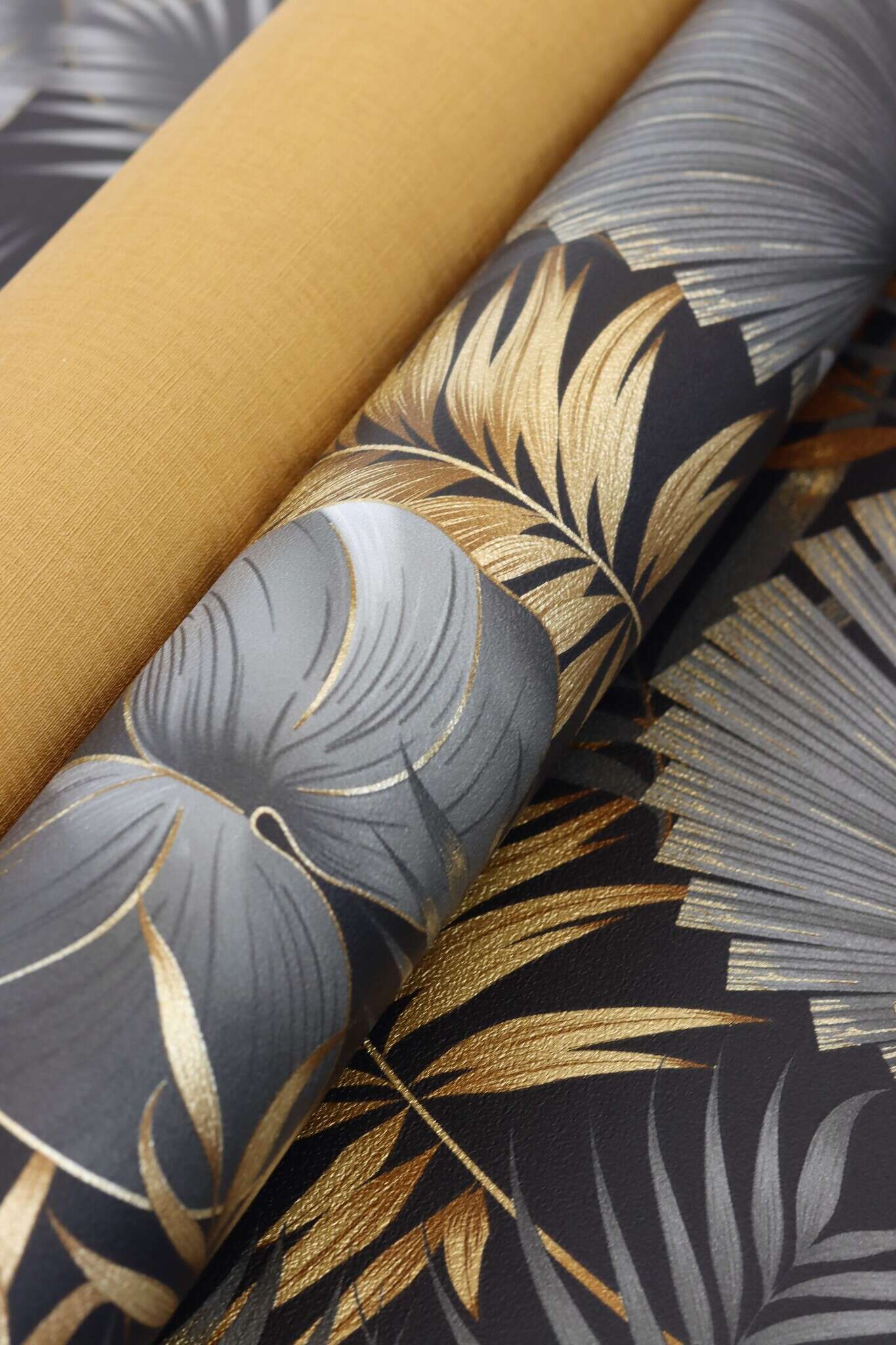 10-462043 Detailaufnahmen 11 Detailed image of Lush leaf motif with palm and monstera leaves in copper, bronze and grey on a black background